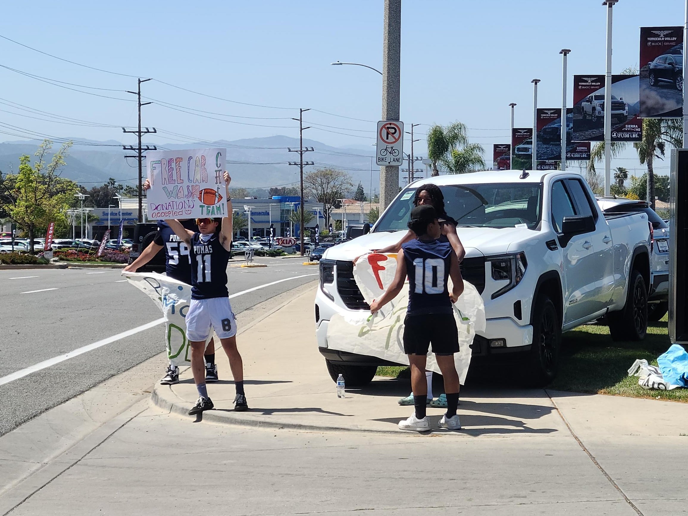 People with signs advertising the football fundraiser
